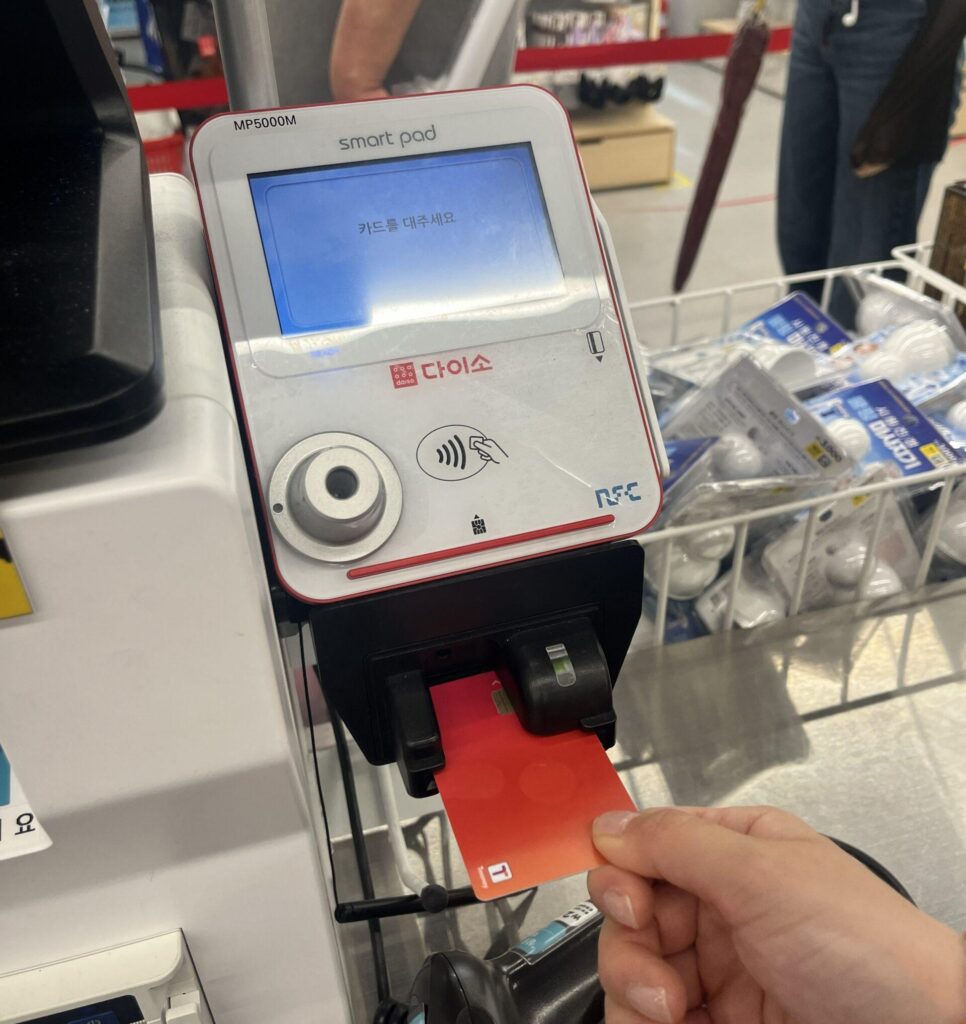 カードリーダー（またはタッチ部分）にTmoneyカードを置きます。